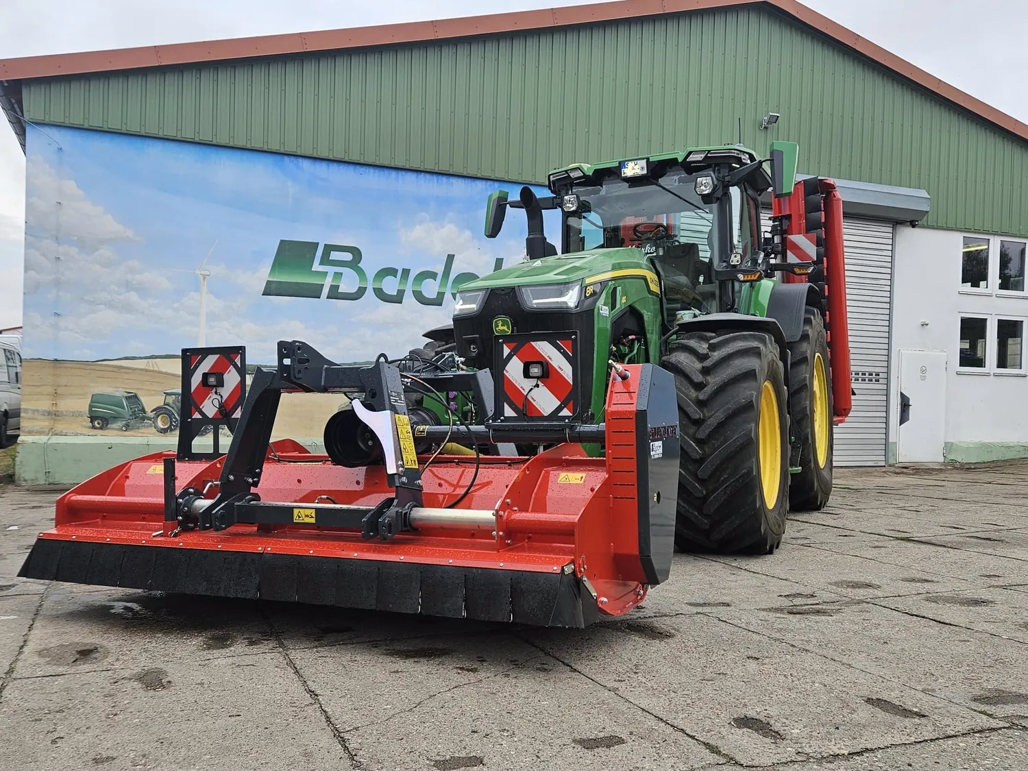 John Deere Traktor mit großem Anbaugerät vor der LBadel-Halle